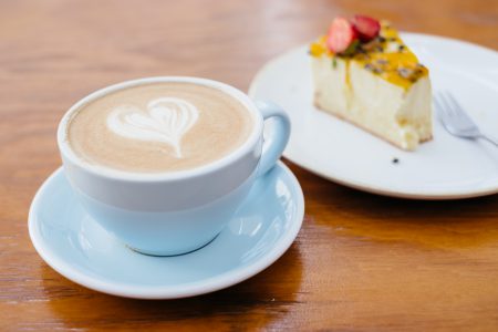 Latte and a cheesecake on a café table - free stock photo