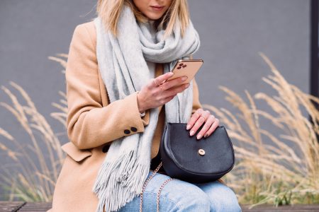 Female holding her phone and purse on an autumn day - free stock photo