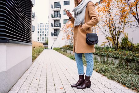 Female holding her phone on an autumn day - free stock photo