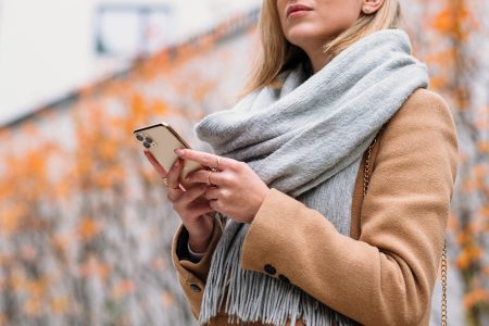 Female holding her phone on an autumn day closeup - free stock photo