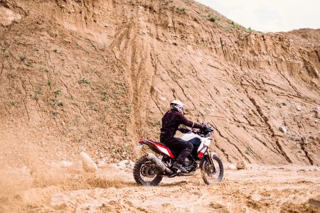 Motor biker riding through a sand quarry - free stock photo