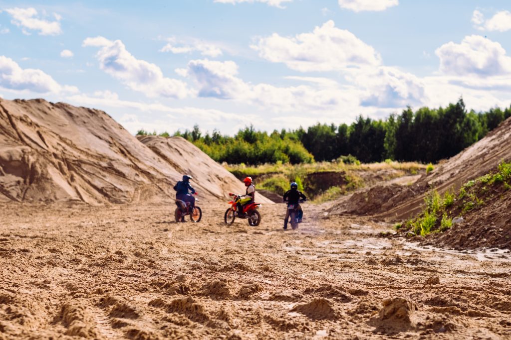 Three bikers at a sand quarry - free stock photo