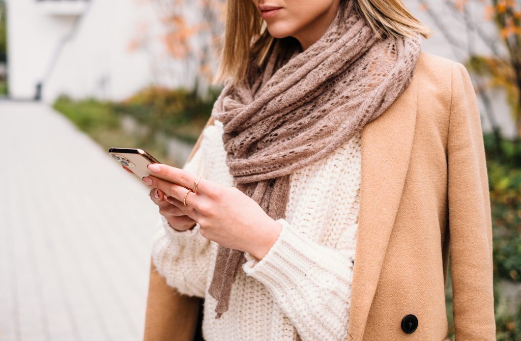 Female holding her phone on an autumn day closeup 2 - free stock photo