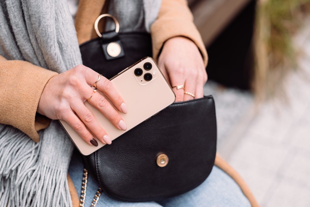 Female looking for something in her purse on an autumn day closeup - free stock photo