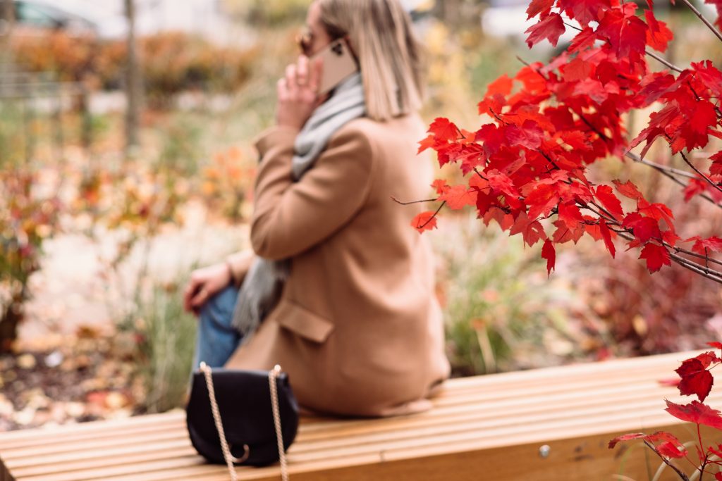 Female sitting on a bench and talking on the phone blur - free stock photo