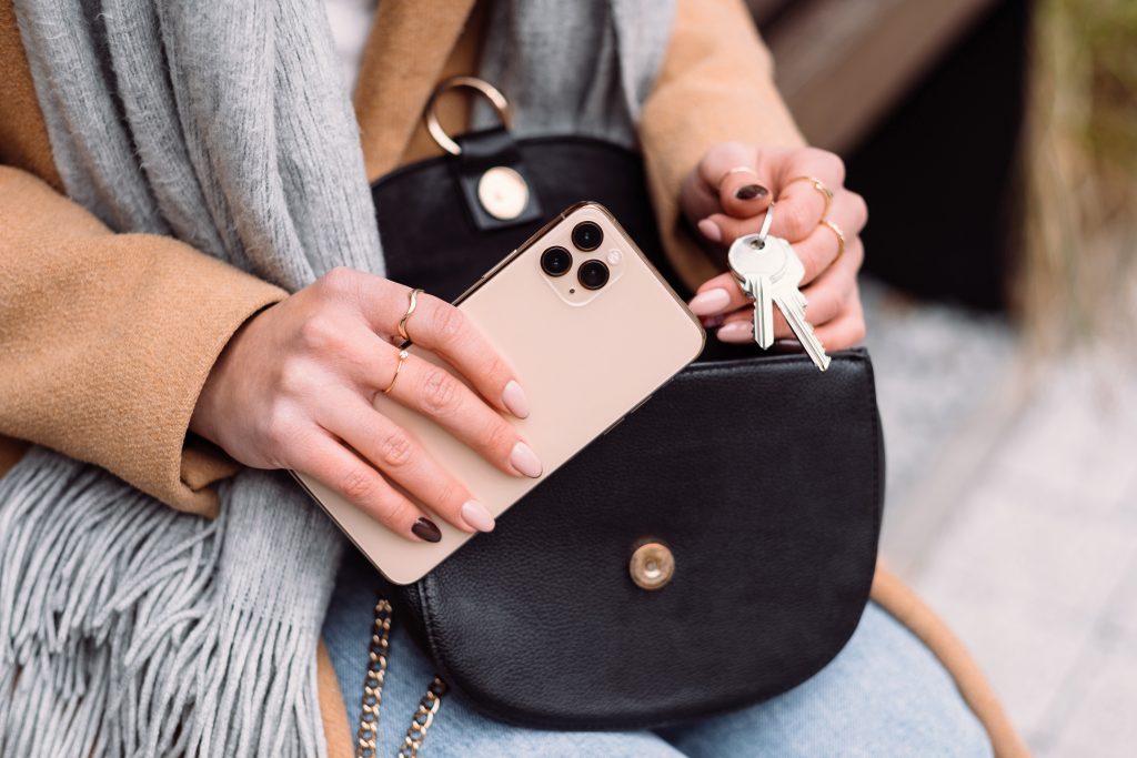 Female taking out the keys from her purse on an autumn day closeup - free stock photo