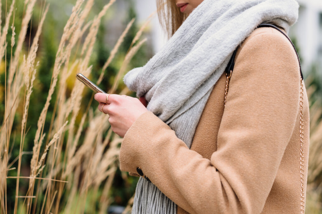 Female holding her phone on an autumn day closeup 4 - free stock photo