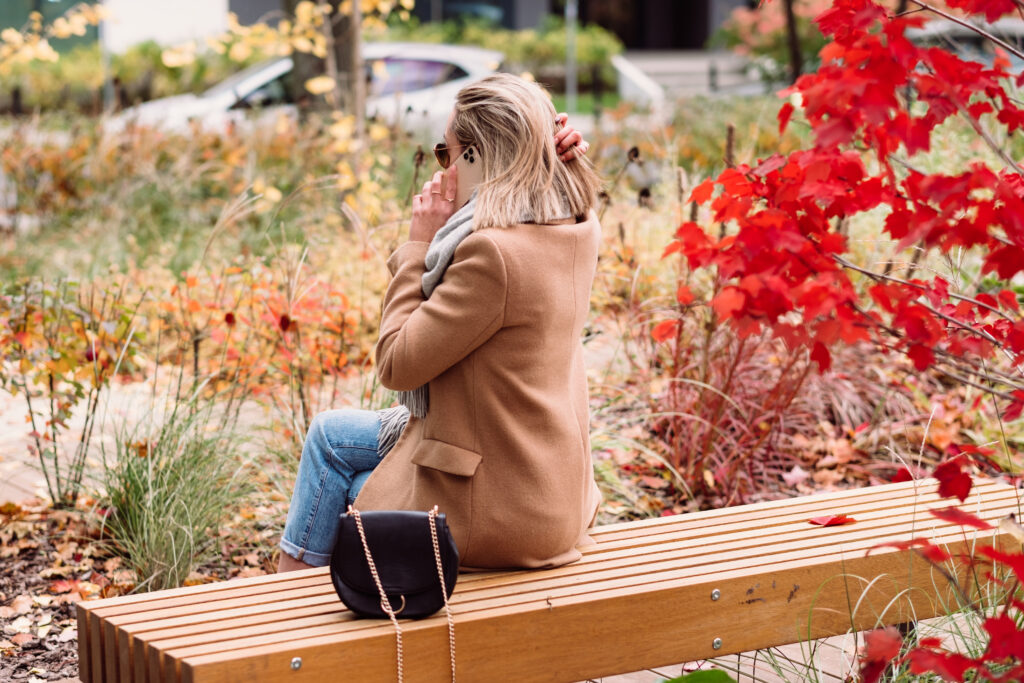 Female sitting on a bench and talking on the phone - free stock photo