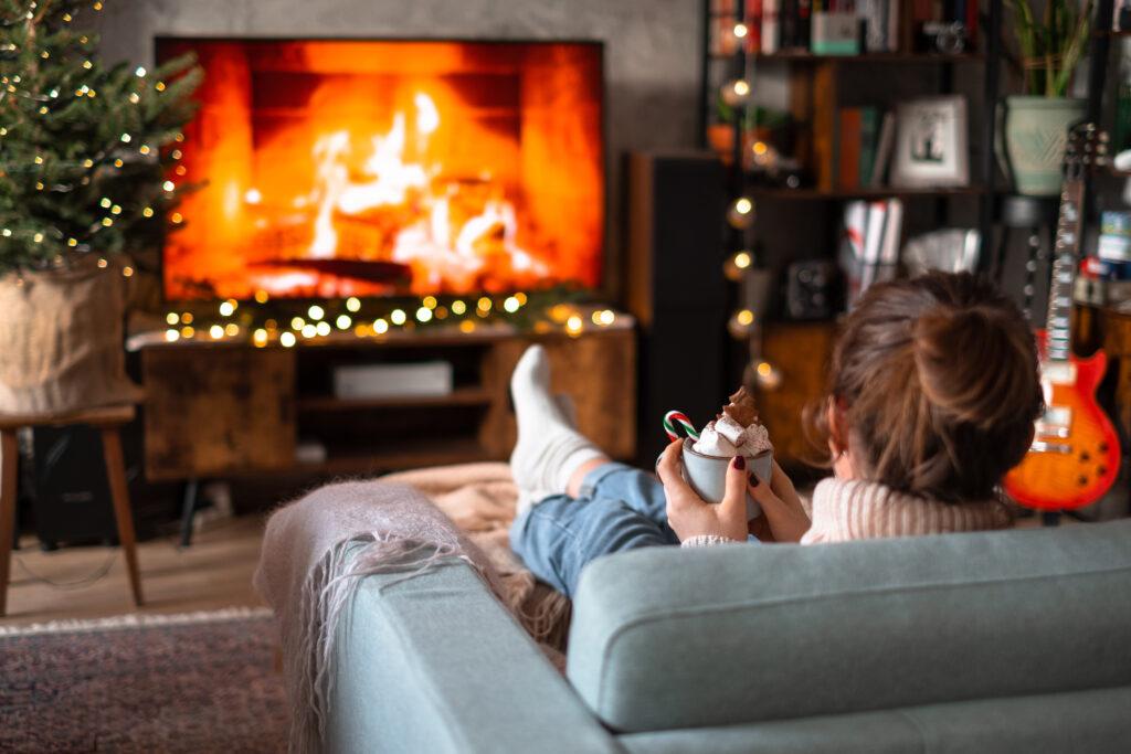 Female relaxing on a sofa holding a mug on Christmas - free stock photo