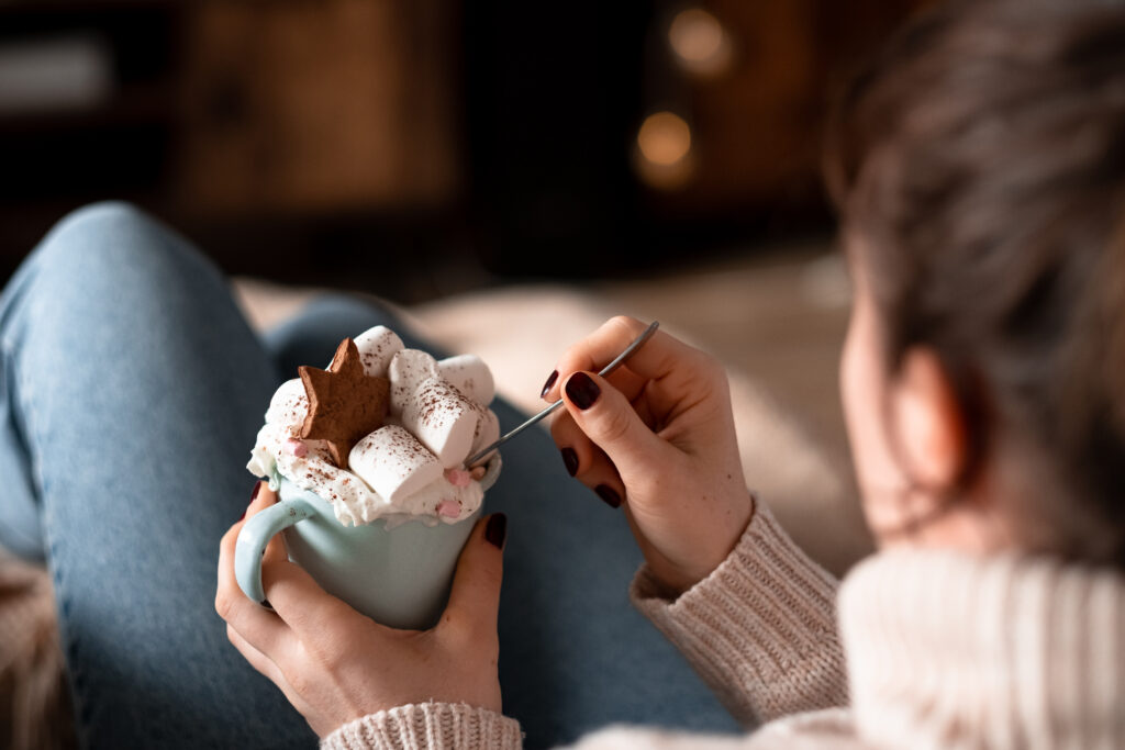 Female relaxing on a sofa holding a mug on christmas closeup - free stock photo