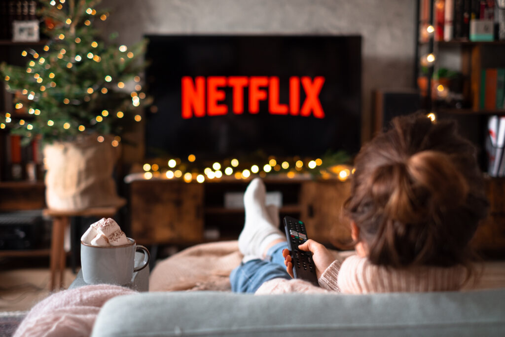 Female sitting on a sofa holding a remote control on Christmas 3 - free stock photo