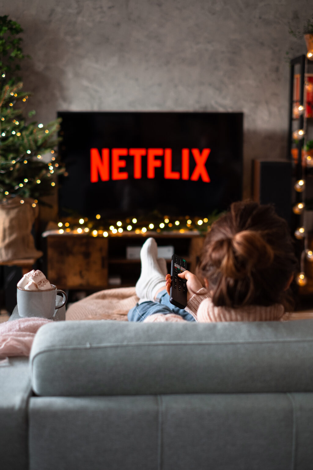 Female sitting on a sofa holding a remote control on Christmas 4 - free stock photo