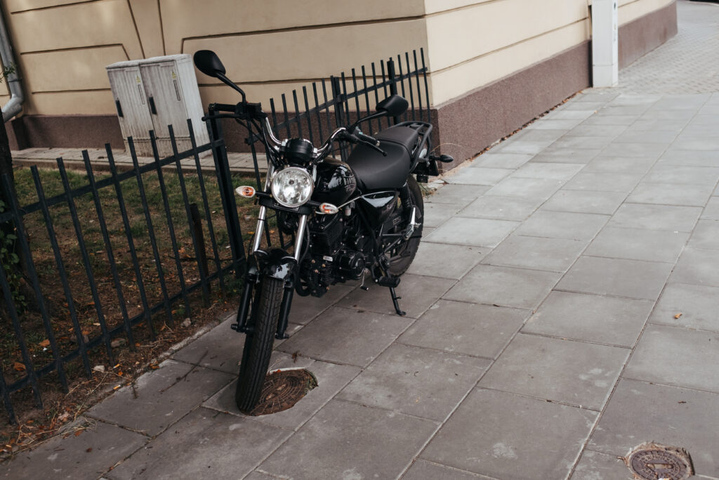 Black motorcycle parked on a sidewalk - free stock photo