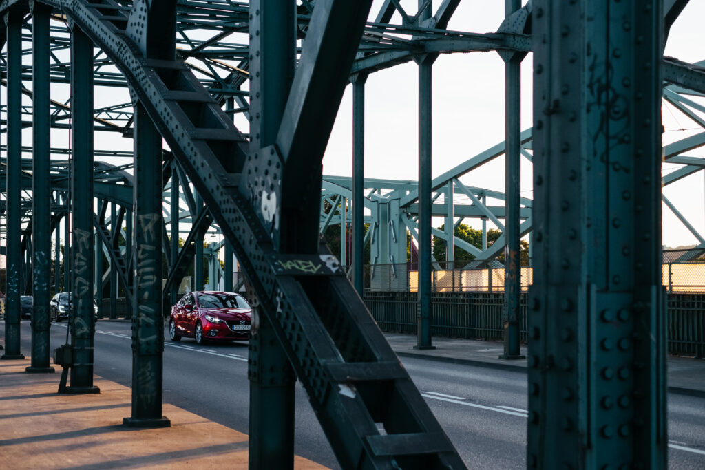 Modern cars driving across an industrial overpass - free stock photo